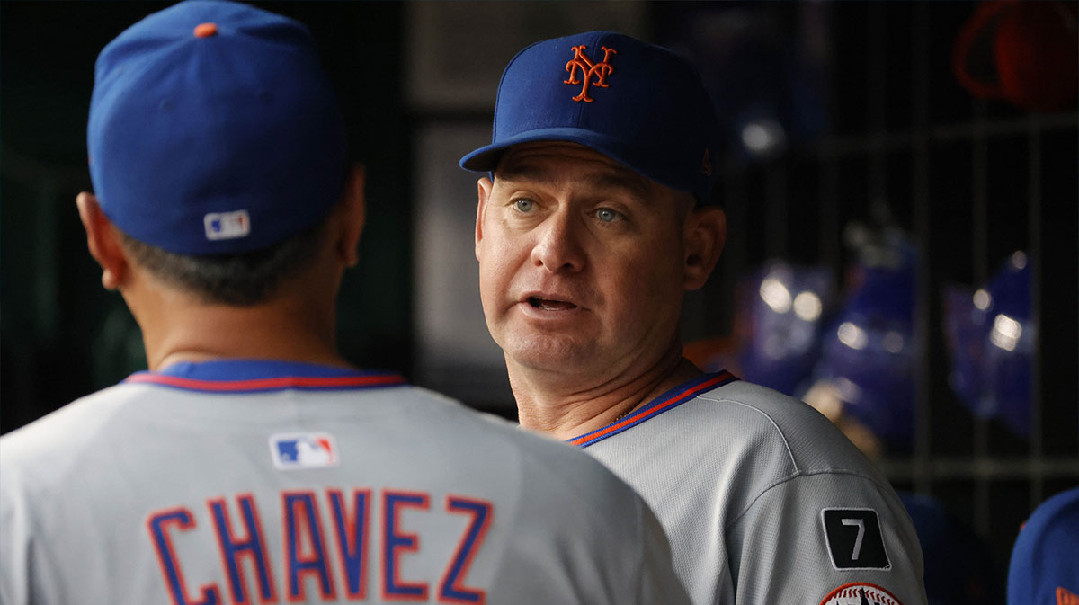 New York Mets manager Carlos Mendoza (64) looks on from the dugout against the Washington Nationals prior to their game at Nationals Park.