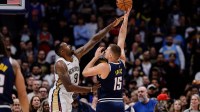 Denver Nuggets center Nikola Jokic (15) shoots the ball under pressure from New Orleans Pelicans center DeAndre Jordan (9) in the first quarter at Ball Arena.