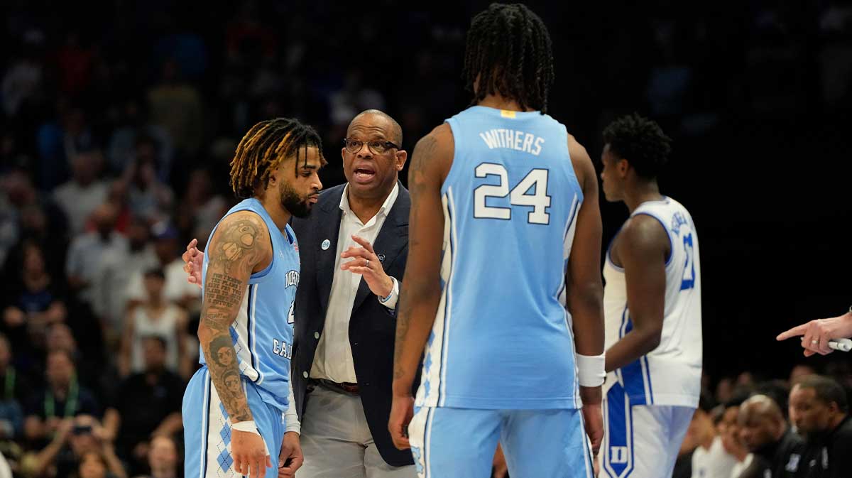 North Carolina Tar Heels head coach Hubert Davis talks with guard RJ Davis (4) as forward Jae'Lyn Withers (24) looks on in the second half at Spectrum Center.