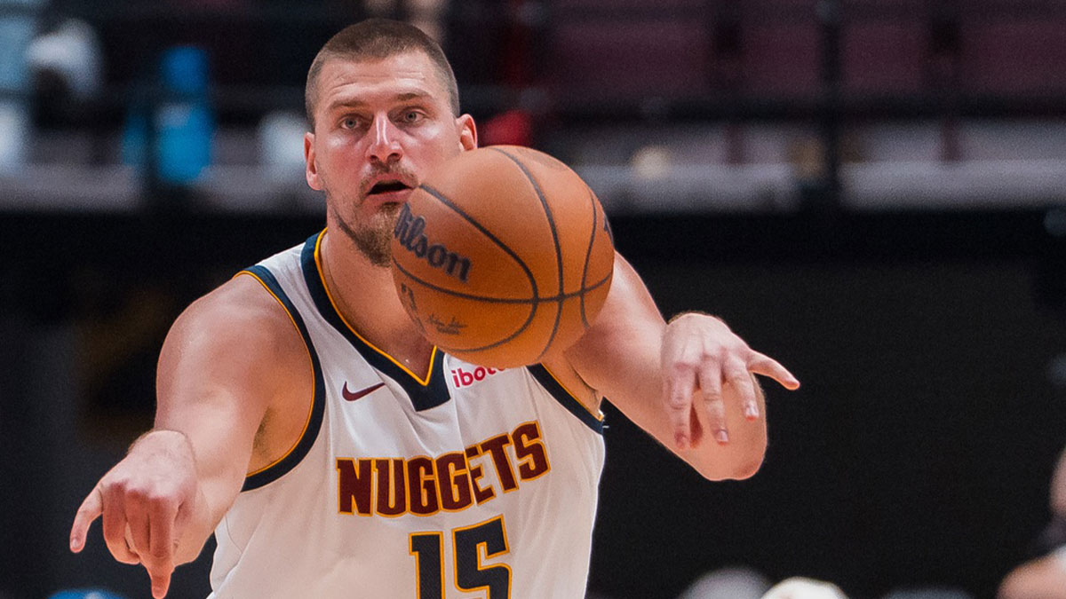 Nuggets center Nikola Jokic (15) makes a pass against the Toronto Raptors in the second half at Rogers Arena with the Thunder logo in the background
