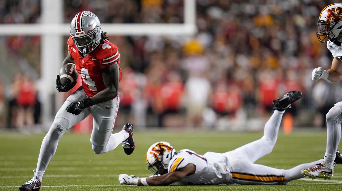 Ohio State Buckeyes wide receiver Jeremiah Smith (4) runp past Minnesota Golden Gophers defenders during the first half of the NCAA football game at Ohio Stadium in Columbus on Oct. 4, 2025.