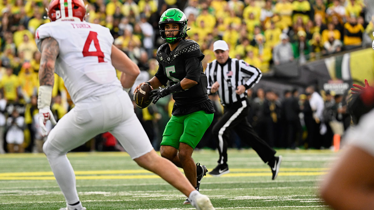 Oregon Ducks quarterback Dante Moore (5) looks to pass the ball against Indiana Hoosiers linebacker Aiden Fisher (4) during the second quarter at Autzen Stadium.