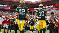 Green Bay Packers quarterbacks Aaron Rodgers (12) and Jordan Love (10) run out onto the field against the Tampa Bay Buccaneers at Raymond James Stadium.