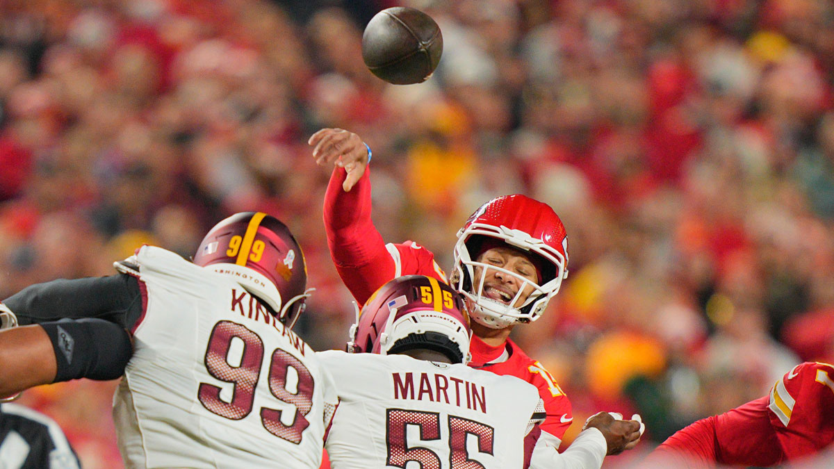 Kansas City Chiefs quarterback Patrick Mahomes (15) passes the ball under pressure from Washington Commanders defensive end Jacob Martin (55) during the first quarter of the game at GEHA Field at Arrowhead Stadium.
