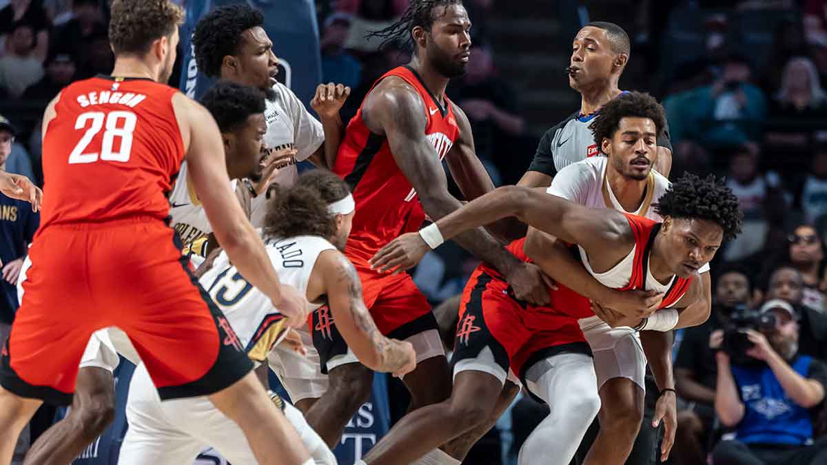 Pelicans' Jose Alvarado (15) and Rockets' Amen Thompson (1) are pulled apart