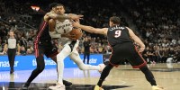 San Antonio Spurs forward Victor Wembanyama (1) drives to the basket between Miami Heat center Kel'el Ware (7) and guard Pelle Larsson (9) during the first half at Frost Bank Center.