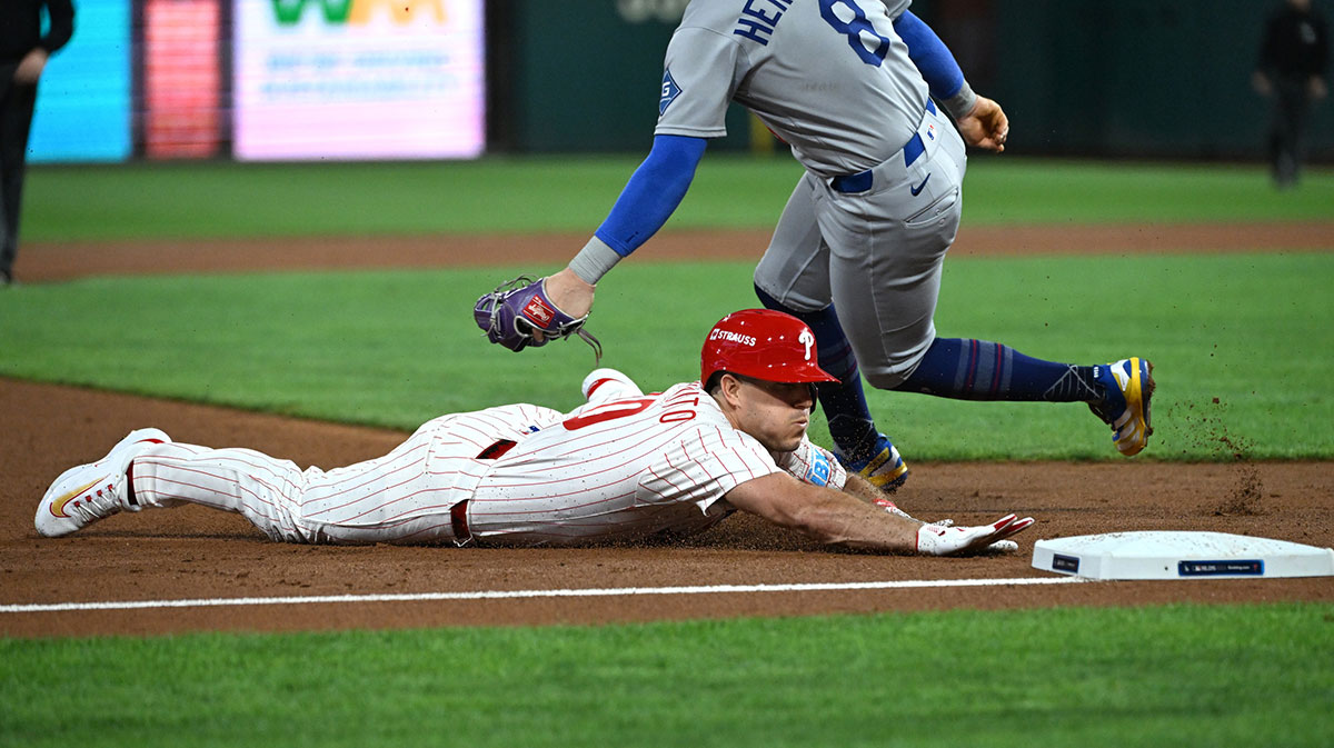 Philadelphia Phillies catcher J.T. Realmuto (10) slides into third against Los Angeles Dodgers first baseman Enrique Hernandez (8) in the second inning during game one of the NLDS round for the 2025 MLB playoffs at Citizens Bank Park.
