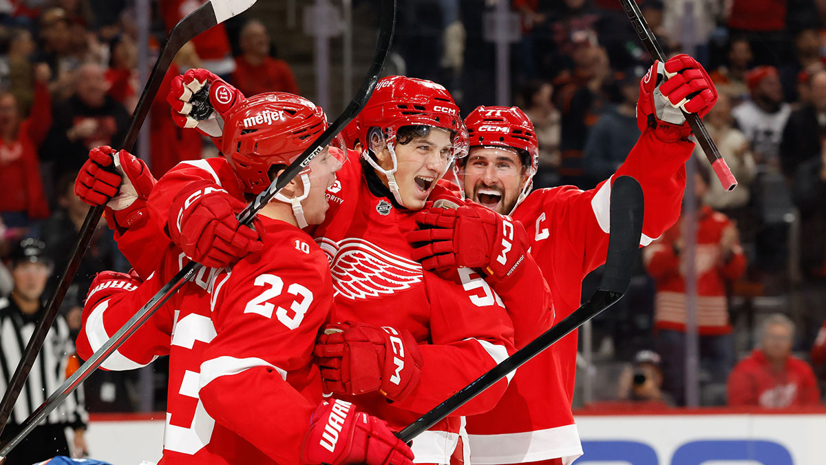 Detroit Red Wings center Emmitt Finnie (58) celebrates with left wing Lucas Raymond (23) and center Dylan Larkin (71) after scoring a goal against the Edmonton Oilers during the second period at Little Caesars Arena.