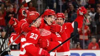 Detroit Red Wings center Emmitt Finnie (58) celebrates with left wing Lucas Raymond (23) and center Dylan Larkin (71) after scoring a goal against the Edmonton Oilers during the second period at Little Caesars Arena.