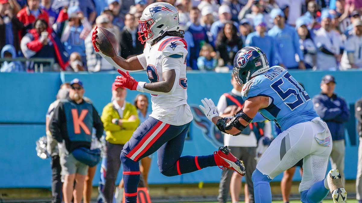 New England Patriots running back Rhamondre Stevenson (38) leaps into the end zone past Tennessee Titans linebacker Cody Barton (50) during the third quarter at Nissan Stadium in Nashville, Tenn., Sunday, Oct. 19, 2025.