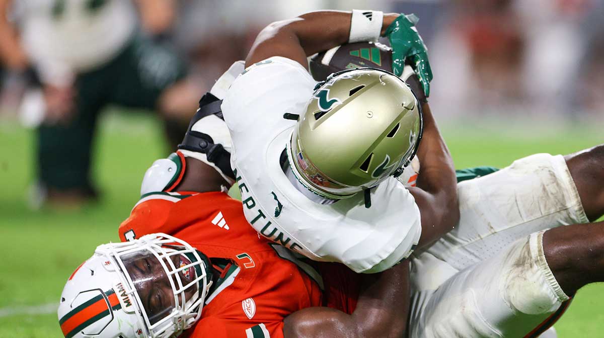 Miami Hurricanes defensive lineman Rueben Bain Jr. (4) tackles South Florida Bulls wide receiver Christian Neptune (81) in the third quarter at Hard Rock Stadium.