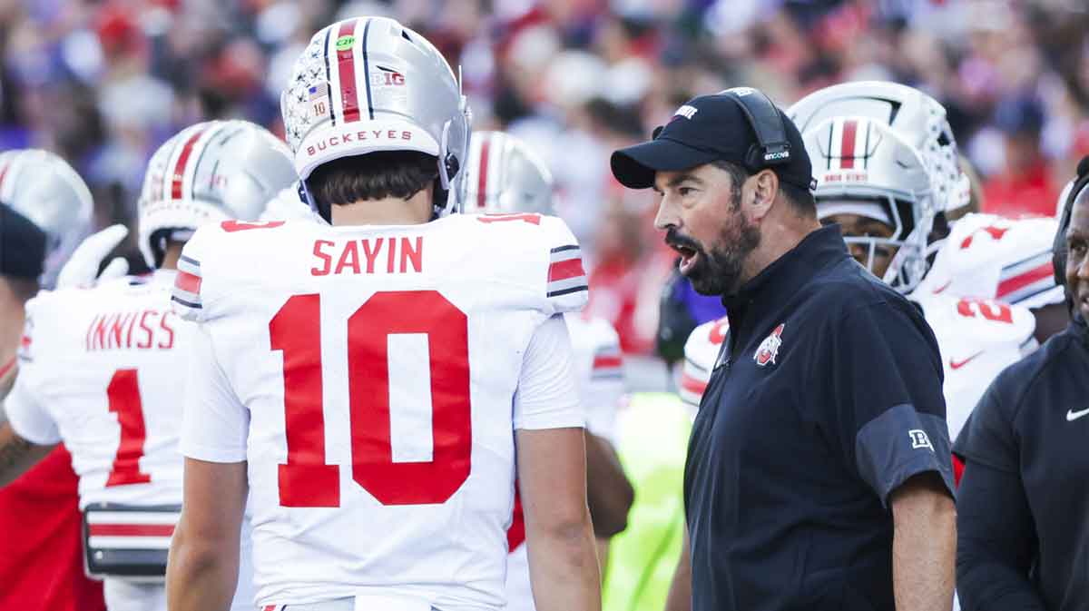 Ohio State Buckeyes head coach Ryan Day speaks with quarterback Julian Sayin (10) during a fourth quarter timeout against the Washington Huskies at Husky Stadium.
