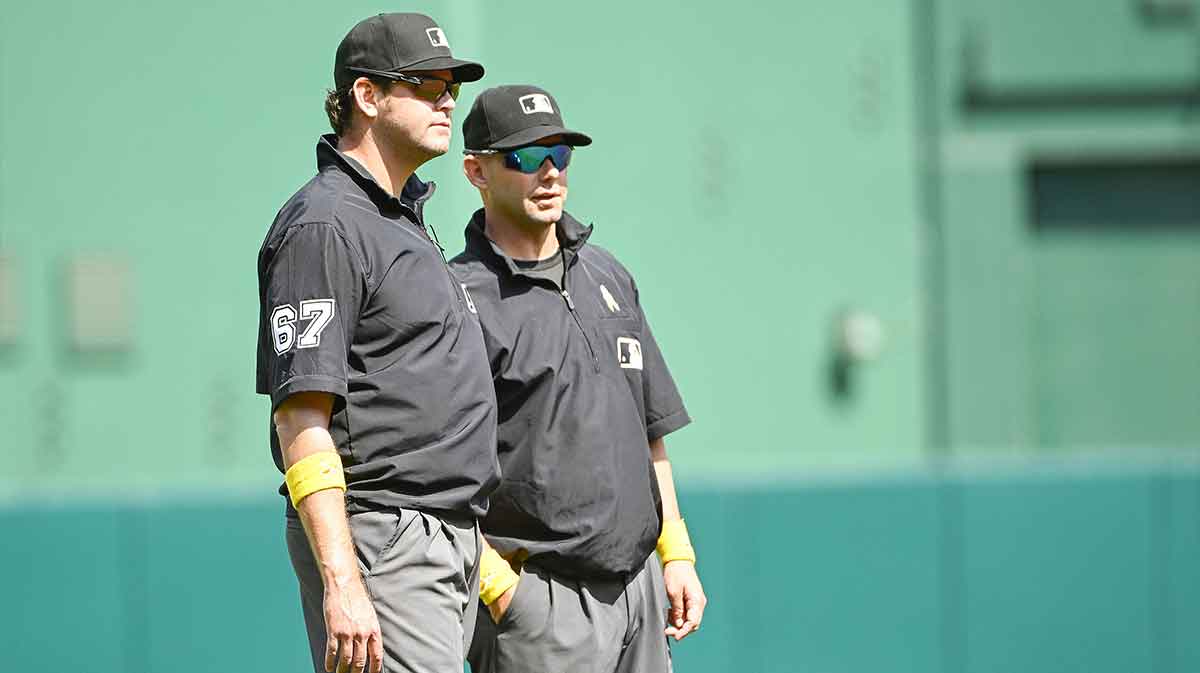 Sep 20, 2023; Washington, District of Columbia, USA; Umpires Ryan Additon (67) and Will Little (93) talk while wearing yellow wristbands in support of childhood cancer awareness during the game between the Washington Nationals and the Chicago White Sox at Nationals Park. Mandatory Credit: Brad Mills-Imagn Images
