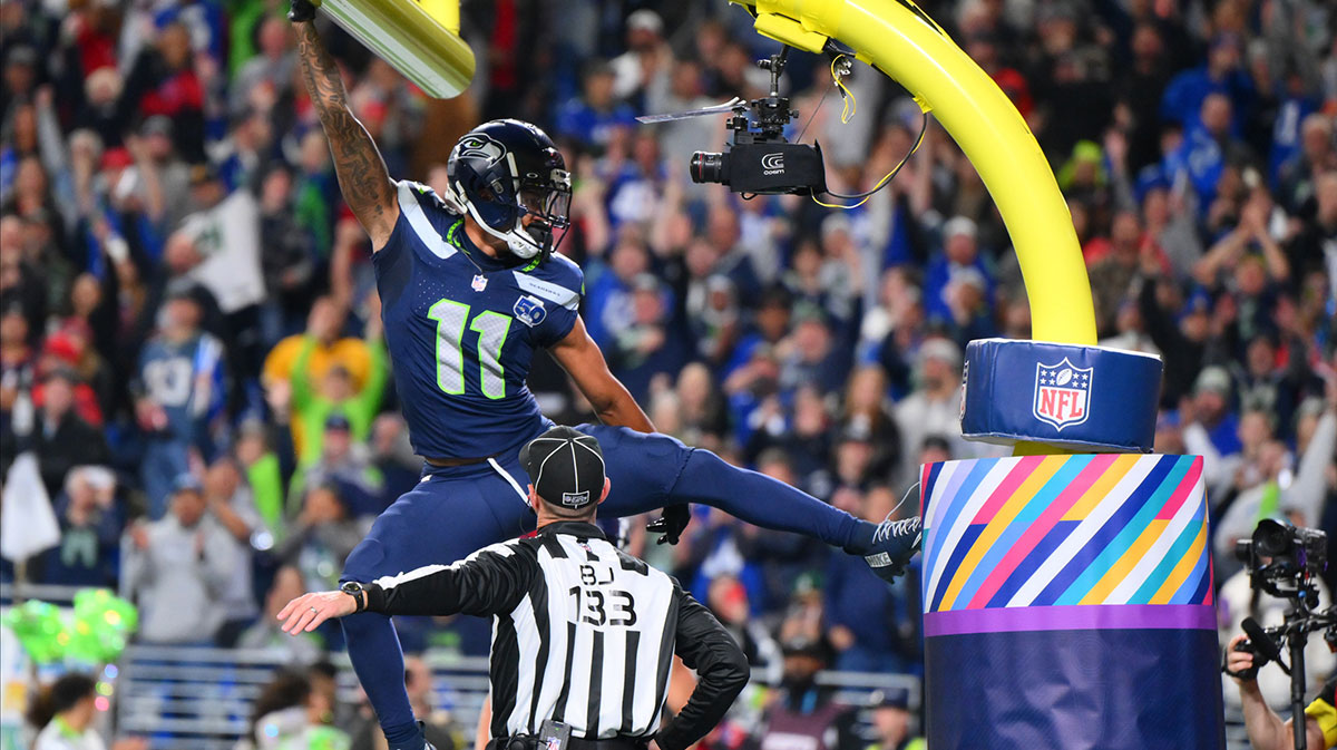 Seattle Seahawks wide receiver Jaxon Smith-Njigba (11) celebrates on the goal post after a touchdown during the first quarter against the Houston Texans at Lumen Field.