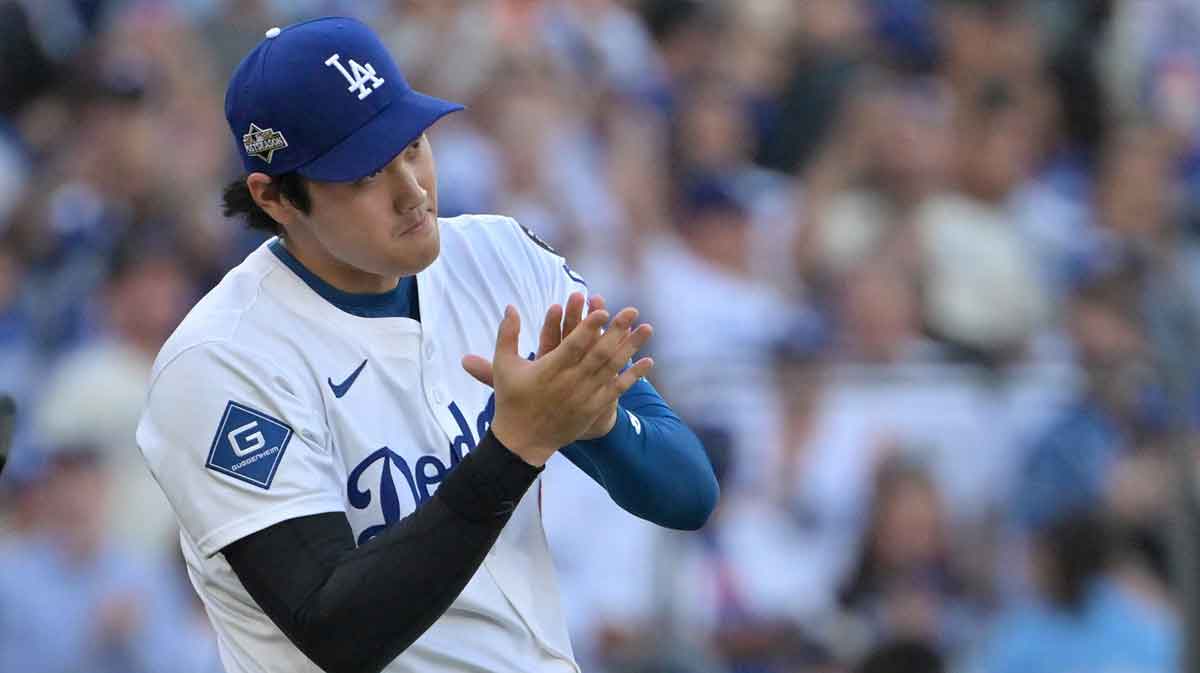 Los Angeles, California, USA; Los Angeles Dodgers designated hitter Shohei Ohtani (17) waits to greet teammates after the final out of the ninth inning of game three of the NLCS during the 2025 MLB playoffs against the Milwaukee Brewers at Dodger Stadium.