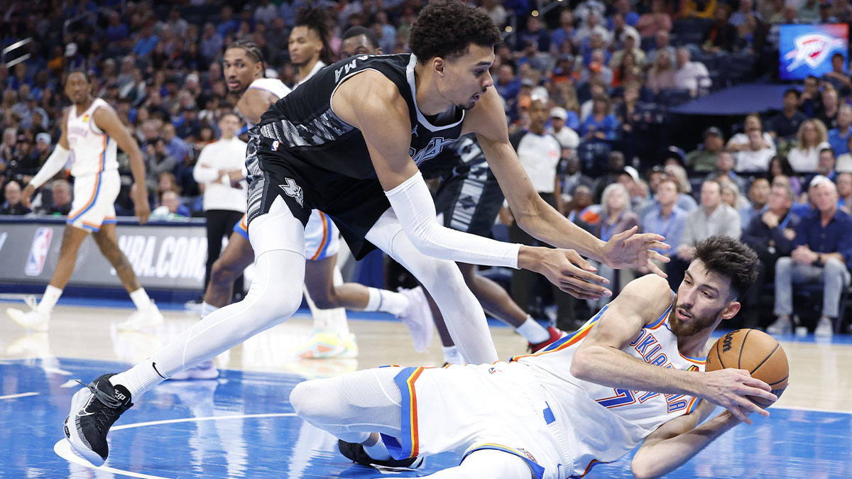 Spurs center Victor Wembanyama (1) works to steal the ball from Oklahoma City Thunder forward Chet Holmgren (7) after he fell to the floor during the second half at Paycom Center