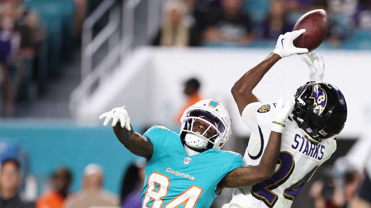 Baltimore Ravens safety Malaki Starks (24) intercepts a pass intended for Miami Dolphins wide receiver Tahj Washington (84) during the fourth quarter at Hard Rock Stadium.