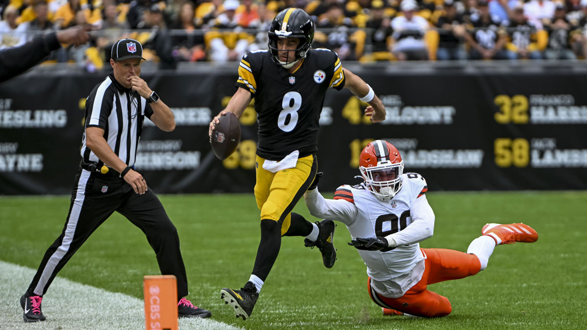 Pittsburgh Steelers quarterback Aaron Rodgers (8) attempts to run the ball while Cleveland Browns defensive end Joe Tryon-Shoyinka (90) pursues during the second quarter at Acrisure Stadium.