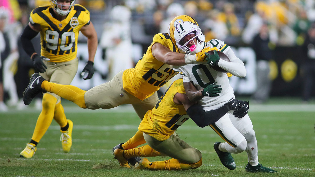 Green Bay Packers wide receiver Matthew Golden (0) gets wrapped up for a tackle by Pittsburgh Steelers linebacker Alex Highsmith (56) and defensive back Chuck Clark (21) during the second half at Acrisure Stadium in Pittsburgh, PA on October 26, 2025.