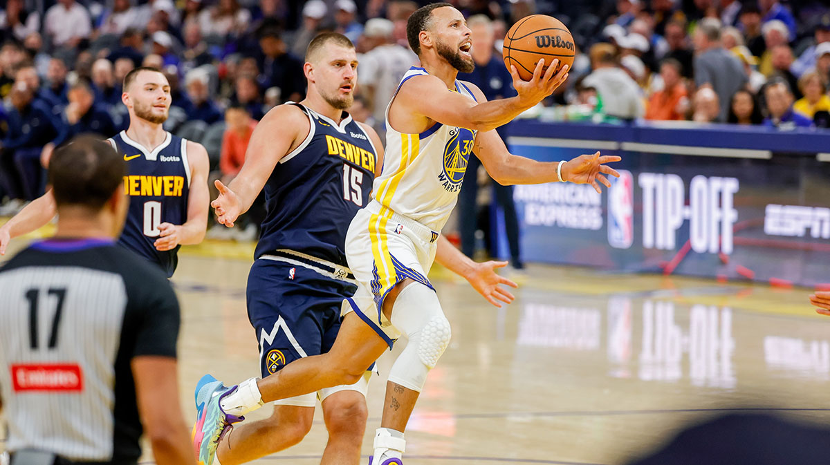 Golden State Warriors guard Stephen Curry (30) goes up for a shot as Denver Nuggets center Nikola Jokić (15) trails on the play during the third quarter at Chase Center.