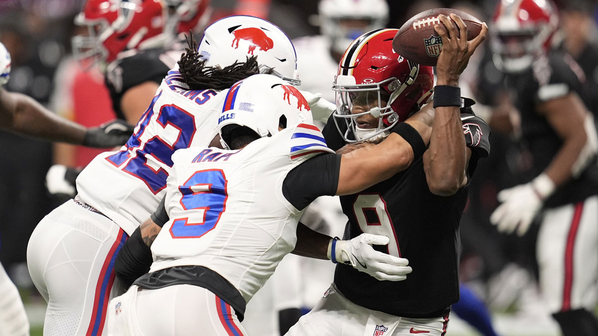 Atlanta Falcons quarterback Michael Penix Jr. (9) is pressured by Buffalo Bills linebacker Dorian Williams (42) and safety Taylor Rapp (9) during the second half of a game at Mercedes-Benz Stadium.