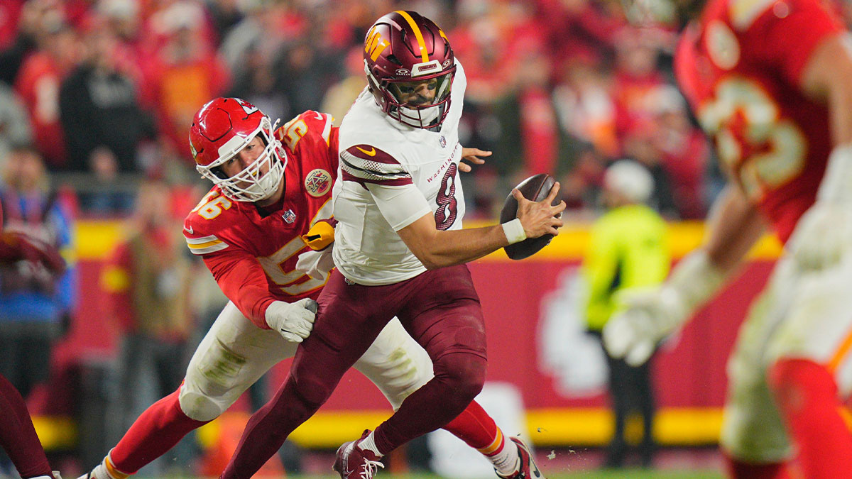 Washington Commanders quarterback Marcus Mariota (8) scrambles defended by Kansas City Chiefs defensive end George Karlaftis (56) during the second quarter of the game at GEHA Field at Arrowhead Stadium.