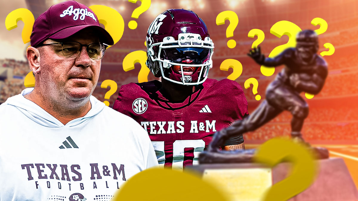 Texas A&M QB Marcel Reed is in between, Mike Elko on the left, Heisman Trophy on the right. and question marks all around