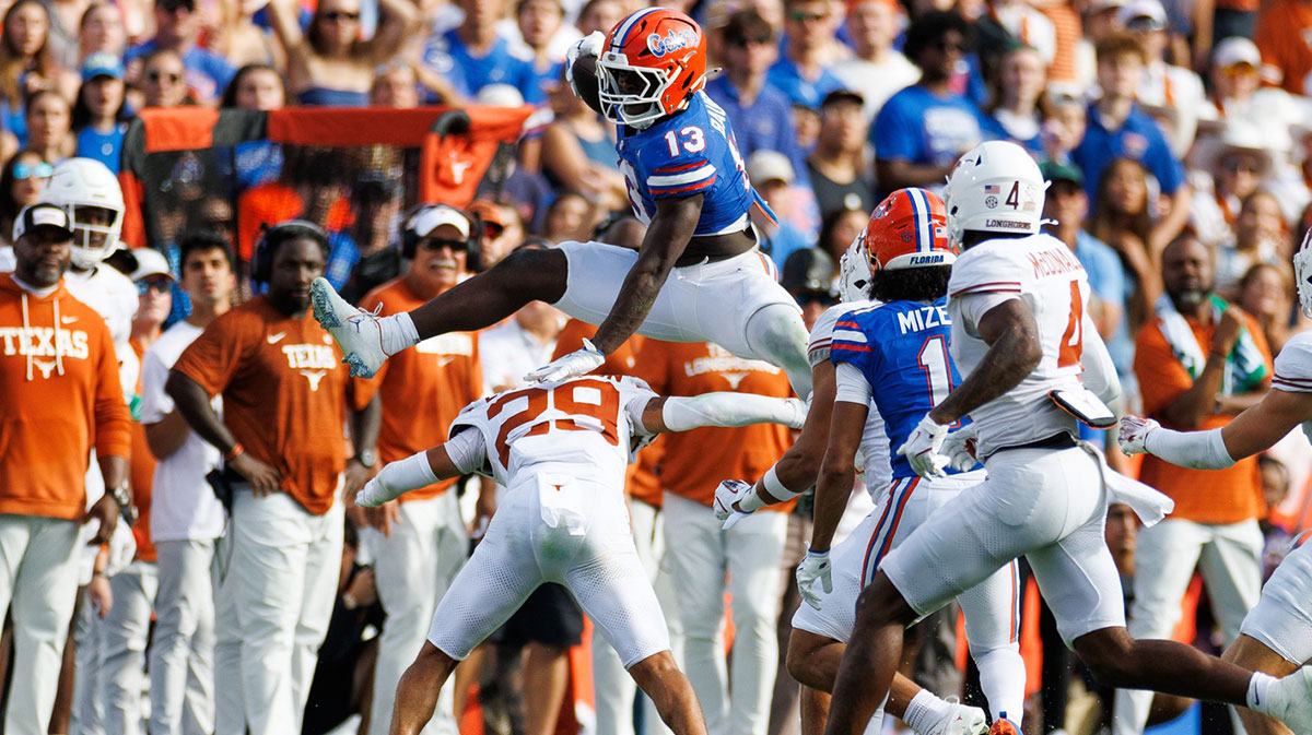 Florida Gators running back Jadan Baugh (13) leaps over Texas Longhorns defensive back Graceson Littleton (29) during the first half at Ben Hill Griffin Stadium. 