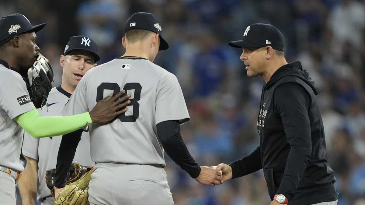 New York Yankees manager Aaron Boone (17) relieves pitcher Will Warren (98) in the eighth inning against the Toronto Blue Jays during game two of the ALDS round for the 2025 MLB playoffs at Rogers Centre.