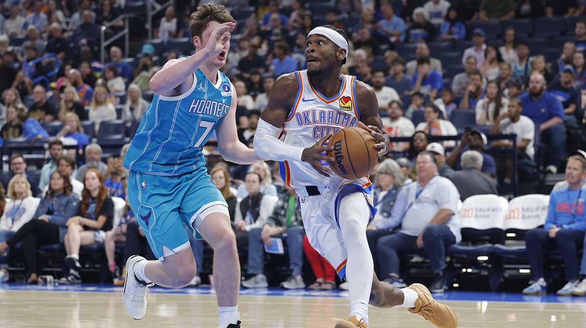 Thunder guard Shai Gilgeous-Alexander (2) drives around Charlotte Hornets guard/forward Kon Knueppel (7) during the second quarter of a game between the Charlotte Hornets and the Oklahoma City Thunder at Paycom Center