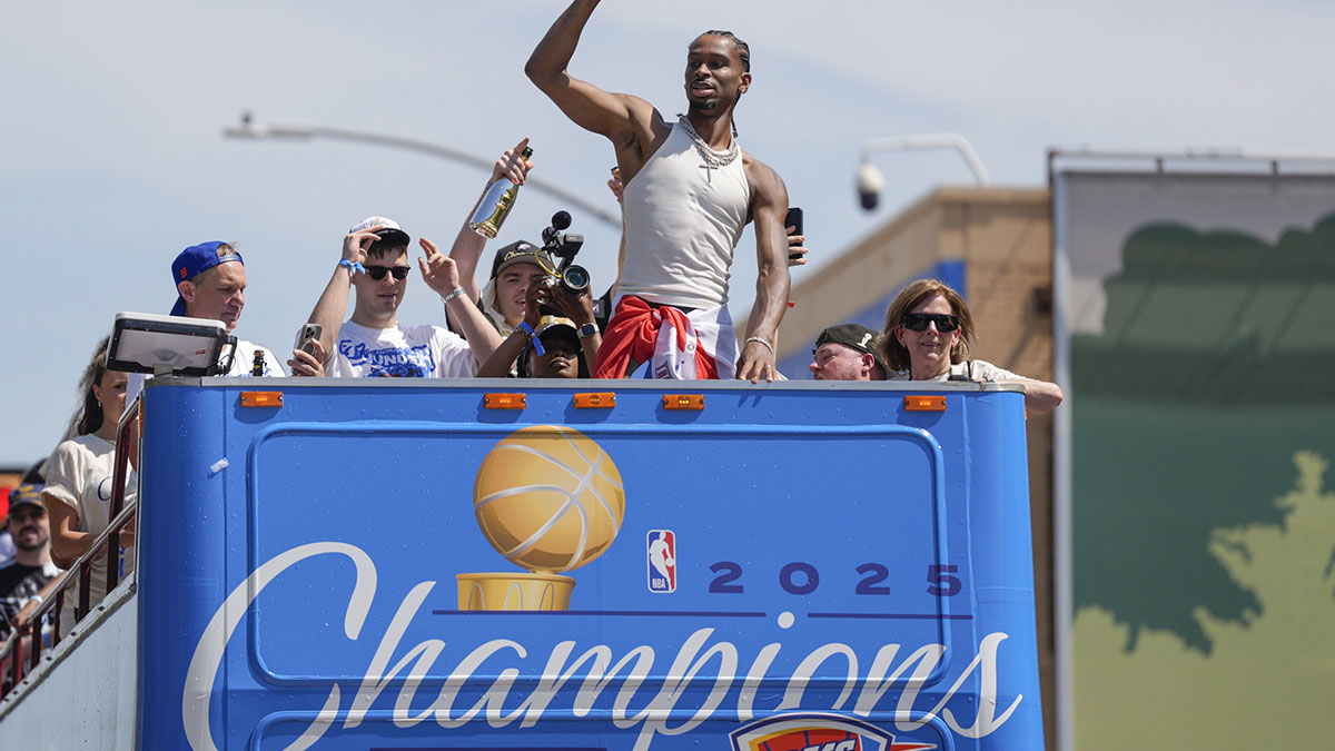 Thunder guard Shai Gilgeous-Alexander gestures to the crowd as the Oklahoma City Thunder celebrate their first NBA Finals title win with a champions parade throughout downtown Oklahoma City on Tuesday, June 24, 2025 with Thunder Opening Night in the background