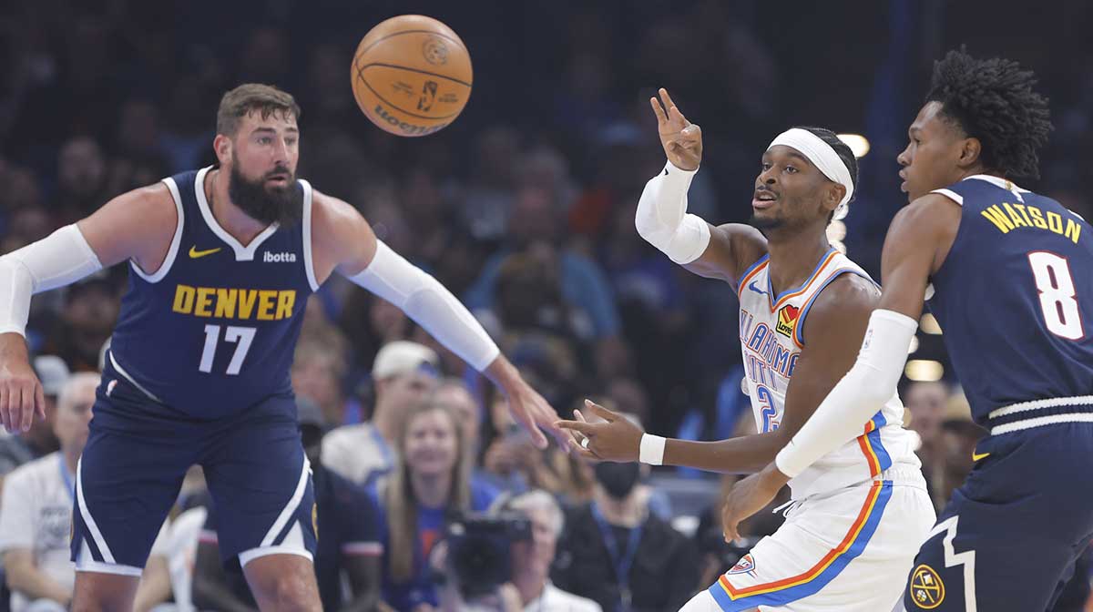 Thunder guard Shai Gilgeous-Alexander (2) passes between Denver Nuggets center Jonas Valančiūnas (17) and guard Peyton Watson (8) during the first quarter at Paycom Center