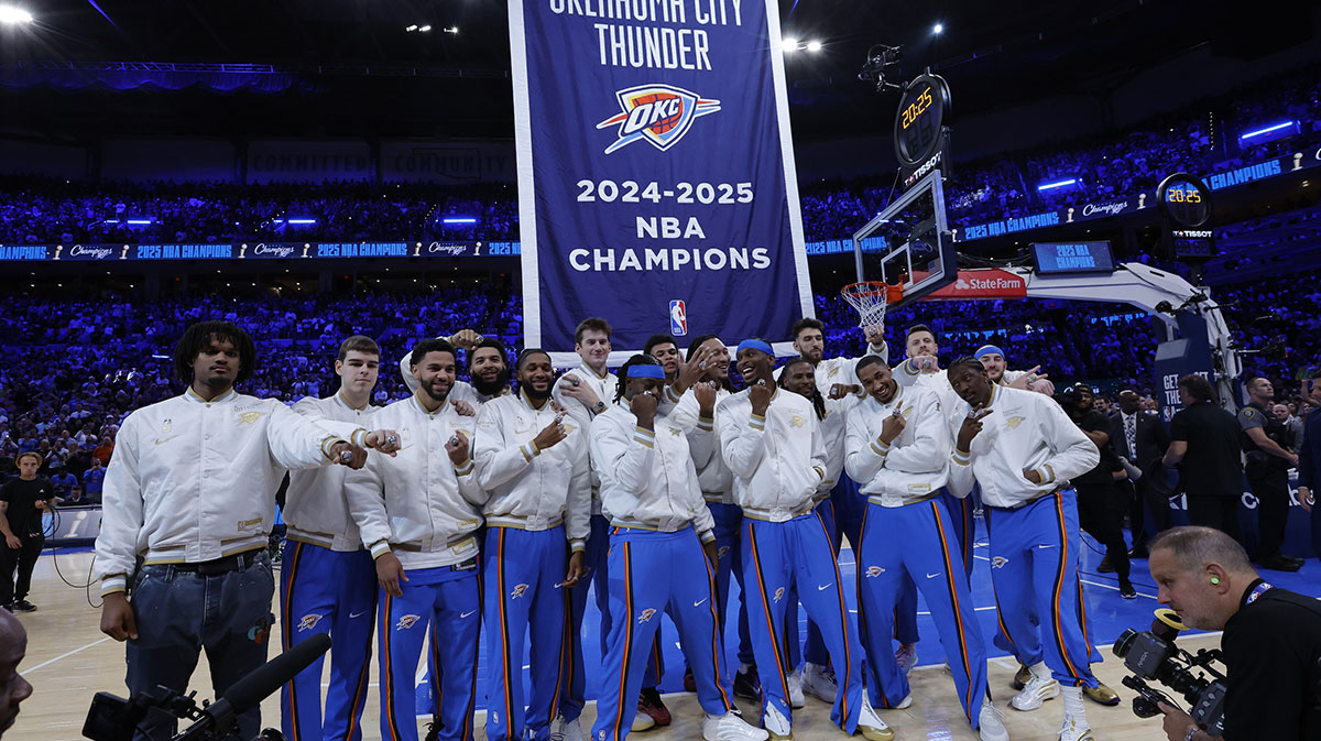 Oklahoma City Thunder celebrate as their championship banner rises behind them during the championship ring and banner ceremony before the start of their game against the Houston Rockets at Paycom Center.