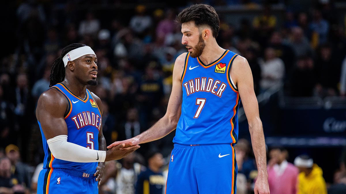 Thunder guard Luguentz Dort (5) and center Chet Holmgren (7) in the second half against the Indiana Pacers at Gainbridge Fieldhouse with the Hawks logo in the background
