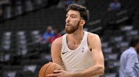 Thunder center Chet Holmgren (7) warms up before the game against the Dallas Mavericks at the American Airlines Center with the Wizards logo in the background