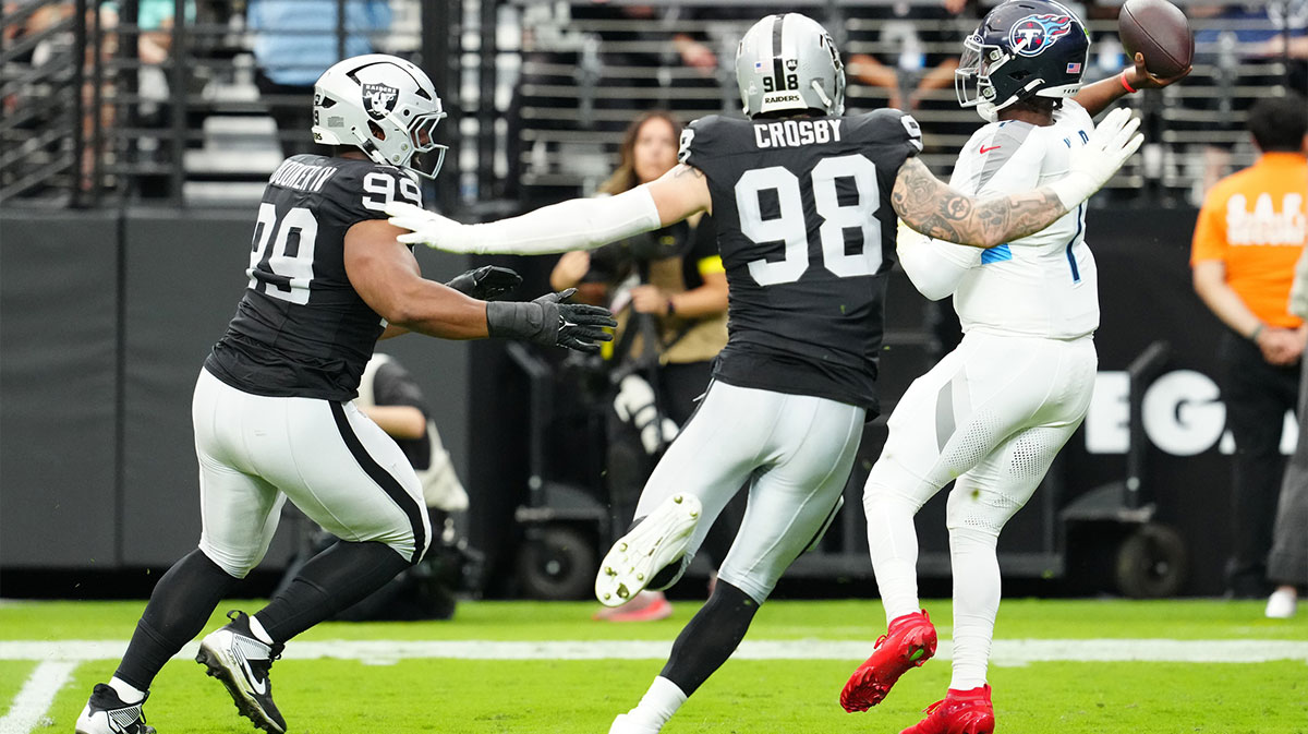 Tennessee Titans quarterback Cam Ward (1) throws the ball away under pressure from Las Vegas Raiders defensive end Maxx Crosby (98) during the second half at Allegiant Stadium.