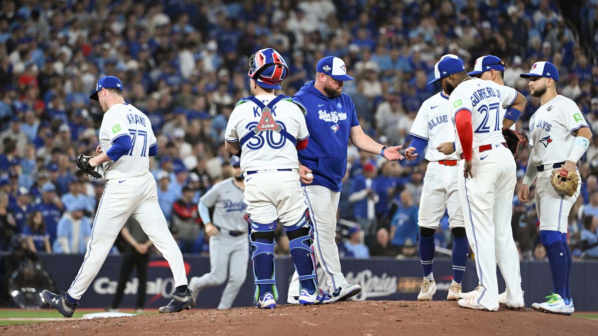 Oct 25, 2025; Toronto, Ontario, CAN; Toronto Blue Jays manager John Schneider (14) takes the ball from pitcher Louis Varland (77) in the eighth inning during game two of the 2025 MLB World Series against the Los Angeles Dodgers at Rogers Centre. Mandatory Credit: Dan Hamilton-Imagn Images