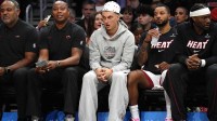 Miami Heat guard Tyler Herro, center, watches the game against the San Antonio Spurs from the bench at Kaseya Center as he recovers from an injury.