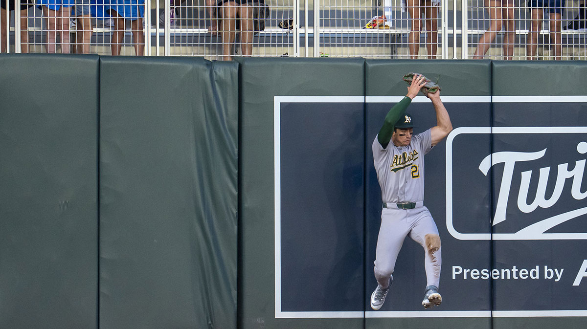 Athletics left fielder Tyler Soderstrom (21) jumps up and catches a fly ball against the left field wall against the Minnesota Twins in the fifth inning at Target Field.