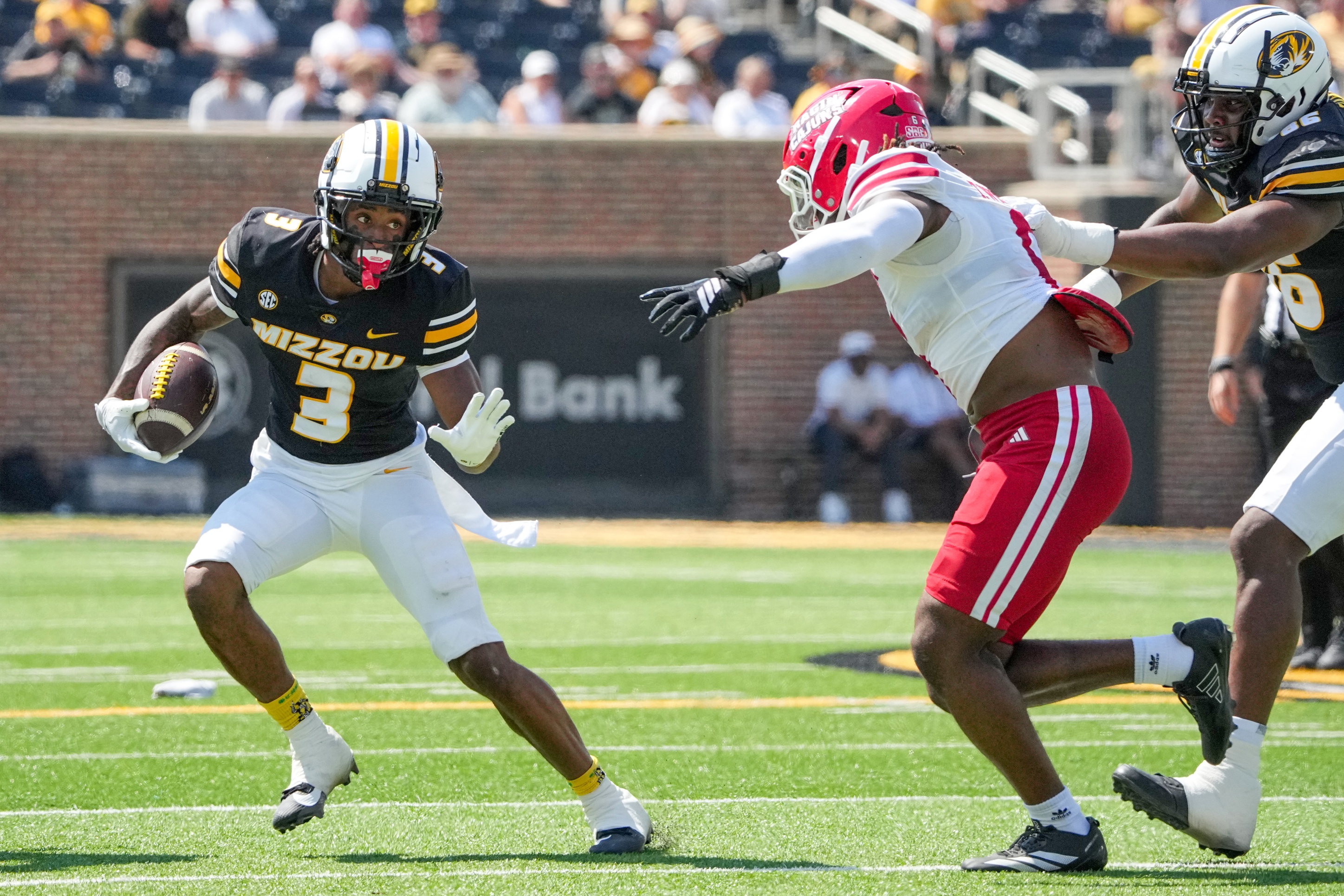 Missouri Tigers wide receiver Kevin Coleman Jr. (3) runs the ball as Louisiana-Lafayette Ragin Cajuns linebacker Terrence Williams (6) defends during the first half of the game at Faurot Field at Memorial Stadium.