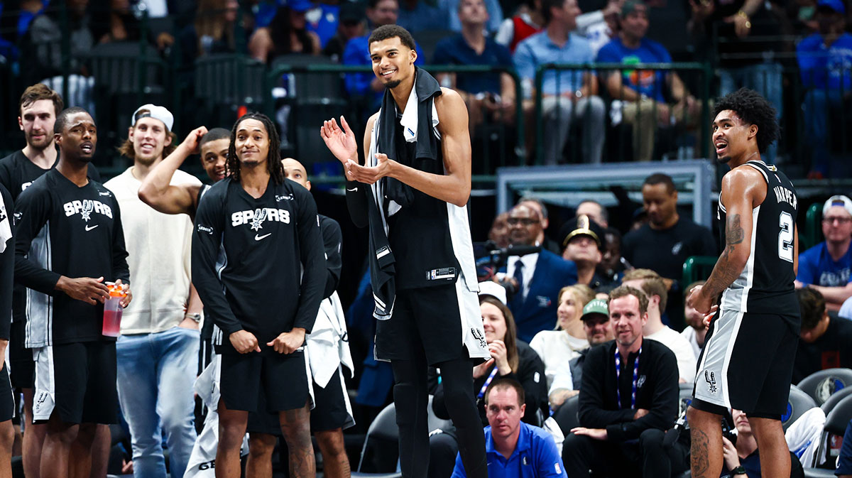 San Antonio Spurs forward Victor Wembanyama (1) and San Antonio Spurs guard Dylan Harper (2) celebrates with teammates during the second half against the Dallas Mavericks at American Airlines Center.