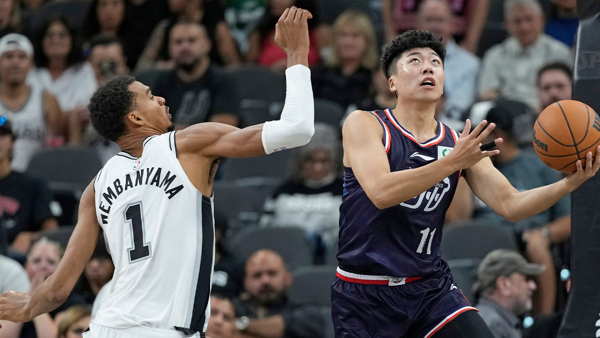 Guangzhou Loong Lions guard Liu Yancheng (11) drives to the basket past San Antonio Spurs forward-center Victor Wembanyama (1) during the first half at Frost Bank Center.