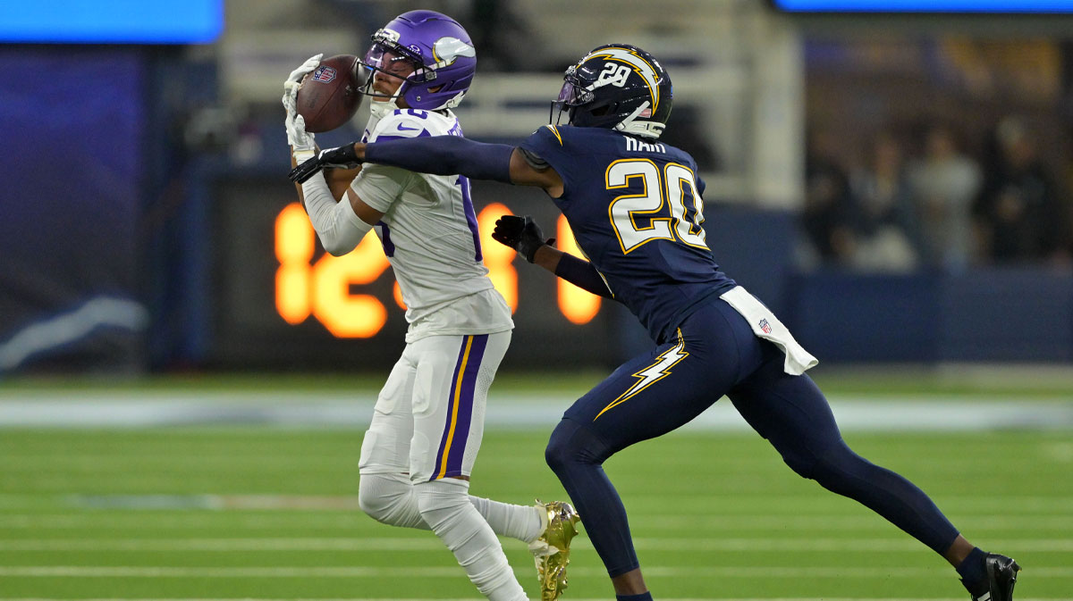Minnesota Vikings wide receiver Justin Jefferson (18) makes a catch over Los Angeles Chargers cornerback Cam Hart (20) during the first half at SoFi Stadium.