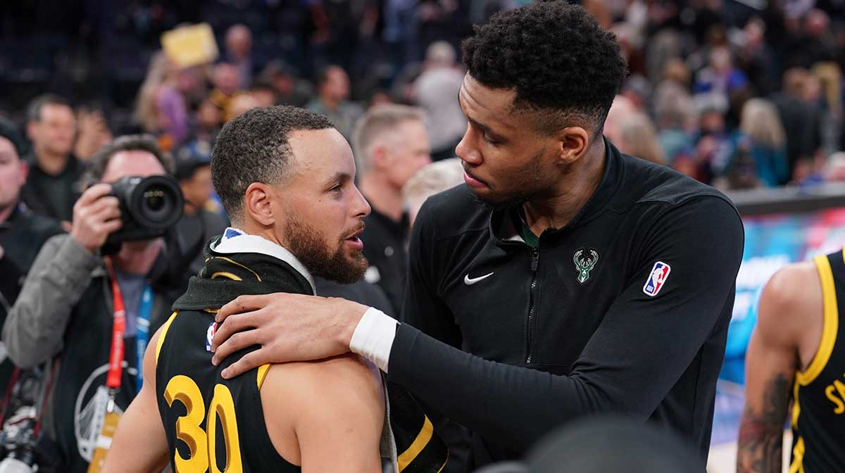 Bucks forward Giannis Antetokounmpo (34) and Golden State Warriors guard Stephen Curry (30) meet after the game at the Chase Center with ESPN's Stephen A Smith in the background