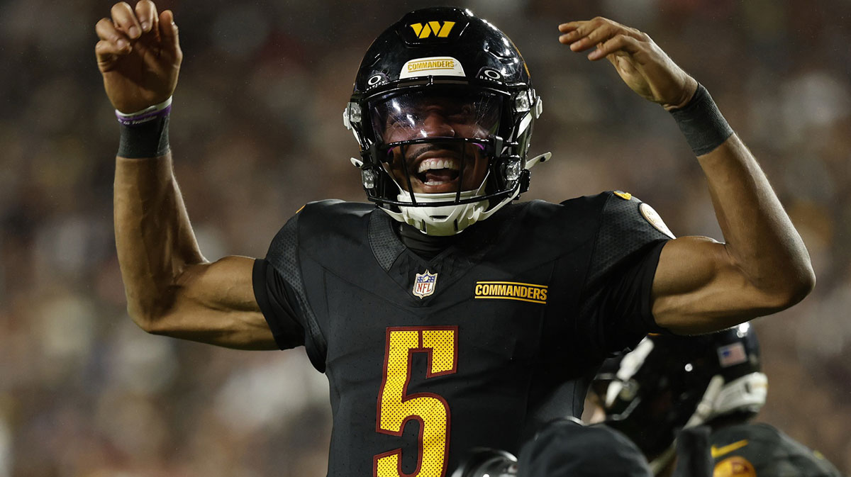 Washington Commanders quarterback Jayden Daniels (5) celebrates after throwing a touchdown pass against the Chicago Bears during the fourth quarter at Northwest Stadium.