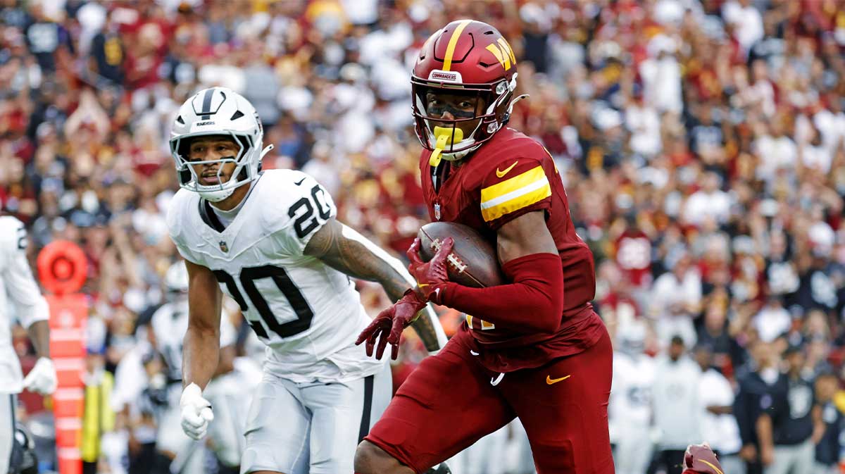 Washington Commanders wide receiver Terry McLaurin (17) runs the ball during the second half as Las Vegas Raiders safety Isaiah Pola-Mao (20) defends at Northwest Stadium.