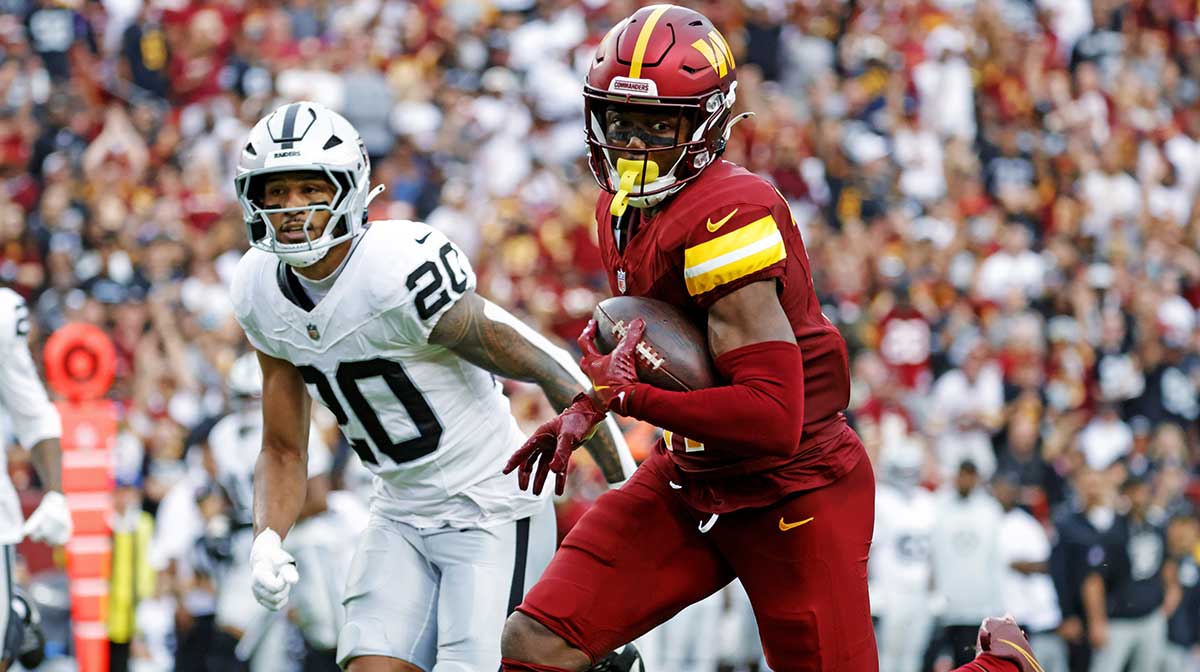 Washington Commanders wide receiver Terry McLaurin (17) runs the ball during the second half as Las Vegas Raiders safety Isaiah Pola-Mao (20) defends at Northwest Stadium.