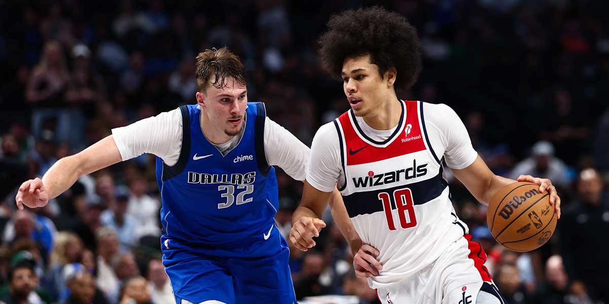 Washington Wizards forward Kyshawn George (18) drives to the basket as Dallas Mavericks forward Cooper Flagg (32) defends during the second half at American Airlines Center.