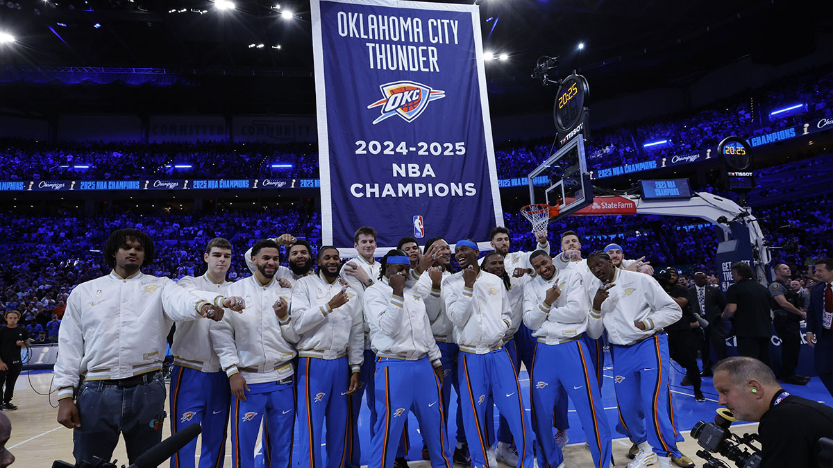 Oklahoma City Thunder celebrate as their championship banner rises behind them during the championship ring and banner ceremony before the start of their game against the Houston Rockets at Paycom Center.