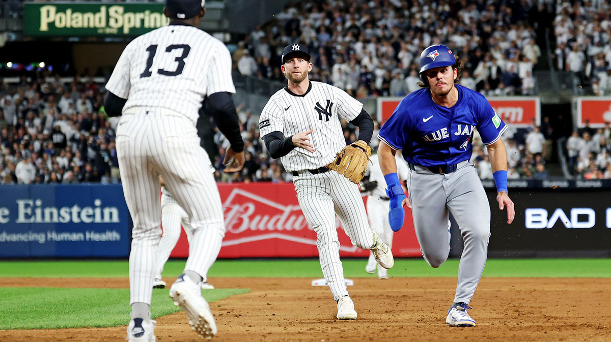 New York Yankees third baseman Ryan McMahon (19) throws to second baseman Jazz Chisholm Jr. (13) to tag out Toronto Blue Jays third baseman Addison Barger (47) at first base during the sixth inning during game four of the ALDS round for the 2025 MLB playoffs at Yankee Stadium.